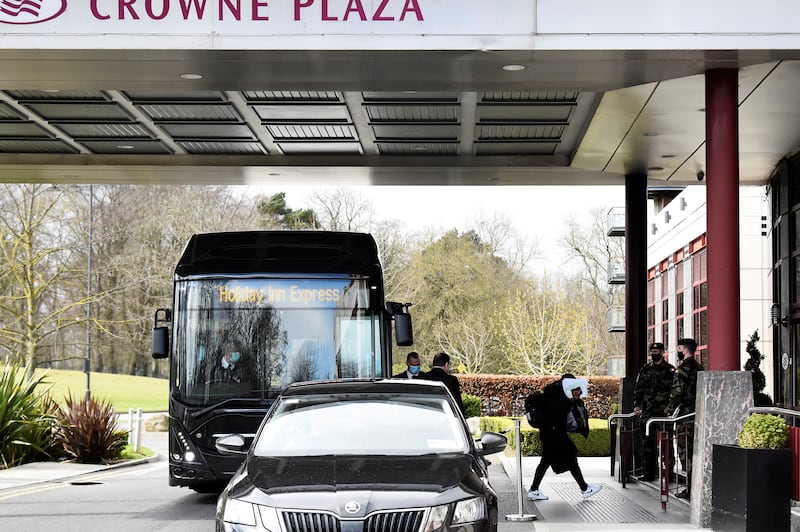 A passenger covers her face after getting off a designated quarantine bus at Crowne Plaza Dublin Airport Hotel, as Ireland introduces hotel quarantine programme for 'high-risk' countries' travellers, in Dublin, Ireland March 26, 2021. REUTERS/Clodagh Kilcoyne