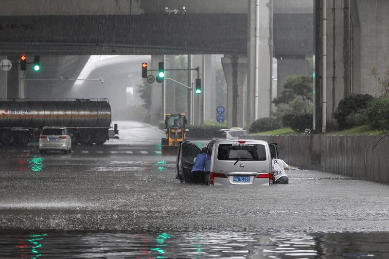 Residents of Zhengzhou in central China's Henan province, push a van along a flooded street.