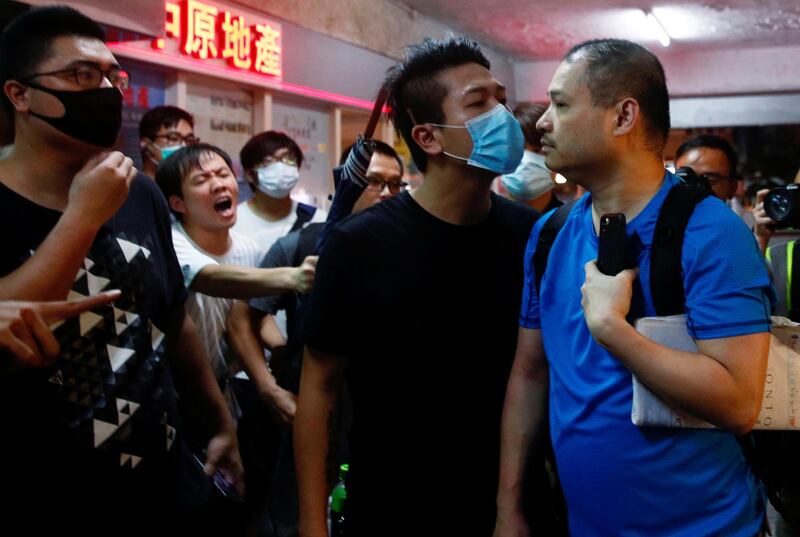 A pro-government supporter is warned by anti-extradition supporters to leave the office building of Mr. Ho. Reuters