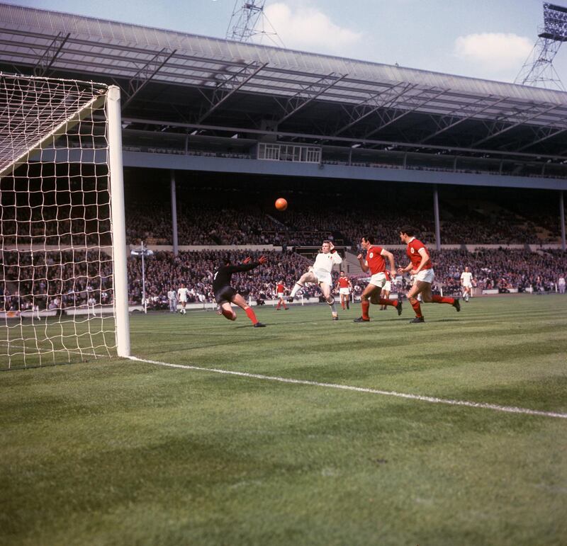 Jose Altafini, Milan centre-forward (white shirt) shoots over the bar during the European Cup final against Benfica at Wembley. Alberto da Costa Pereira, goalkeeper, plunges forward desperately as two of his defenders race in. Milan won 2-1 to wrest the trophy from the Portuguese holders. PA Photos via Reuters