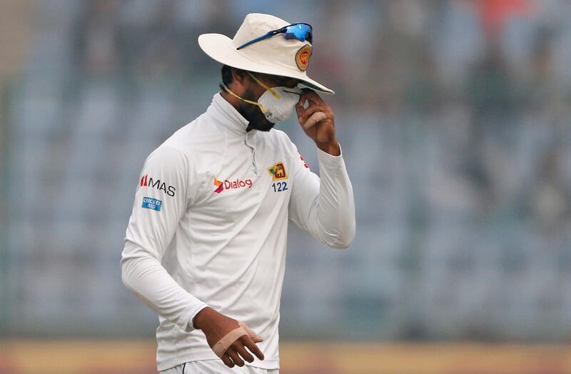 Sri Lanka's captain Dinesh Chandimal adjusts his anti-pollution mask during the fourth day of their third test cricket match against India in New Delhi, India. Altaf Qadri / AP Photo