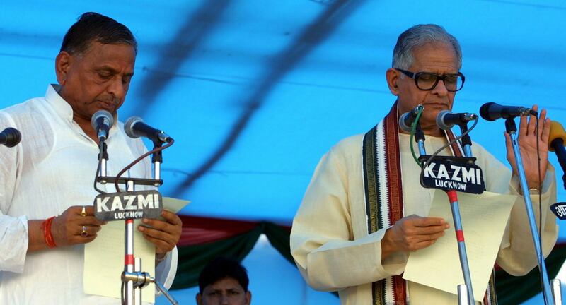 Yadav, left, takes the oath of office during his swearing-in ceremony in Lucknow, India, in August 2003. EPA