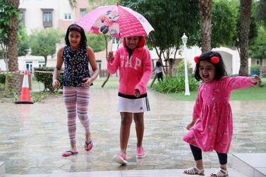 Children enjoy the rain in Furjan community in Dubai. Pawan Singh / The National