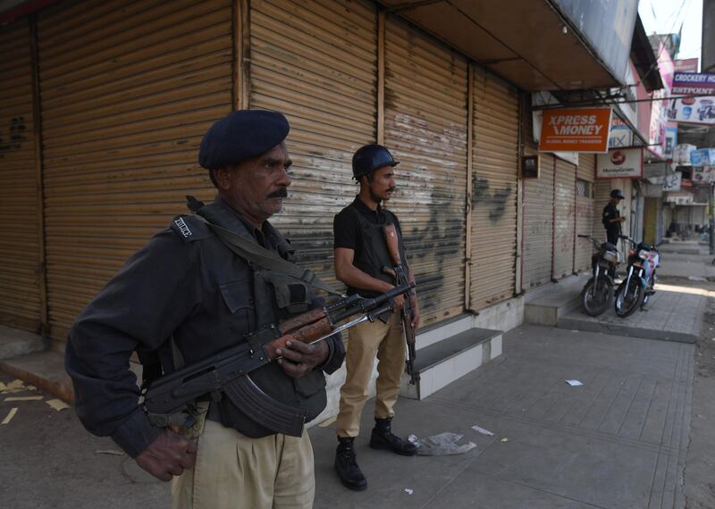 Pakistani policemen stand guard beside a closed market during a protest following the Supreme Court's decision to acquit Pakistani Christian woman Asia Bibi of blasphemy, in Karachi on November 2, 2018. Pakistan's powerful military warned on November 2 its patience had been thoroughly tested after being threatened by Islamist hardliners enraged by the acquittal of a Christian woman for blasphemy, as the country braced for more mass protests. / AFP / ASIF HASSAN
