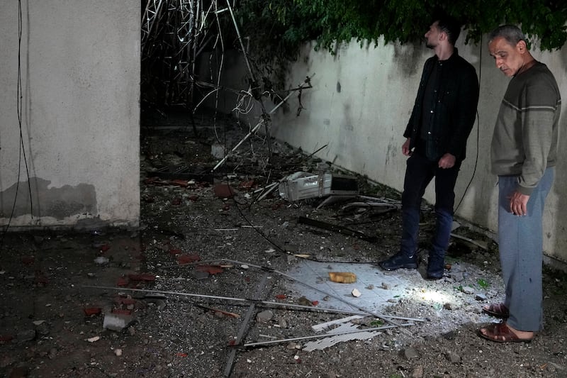 Palestinians inspect damage to their home. AP