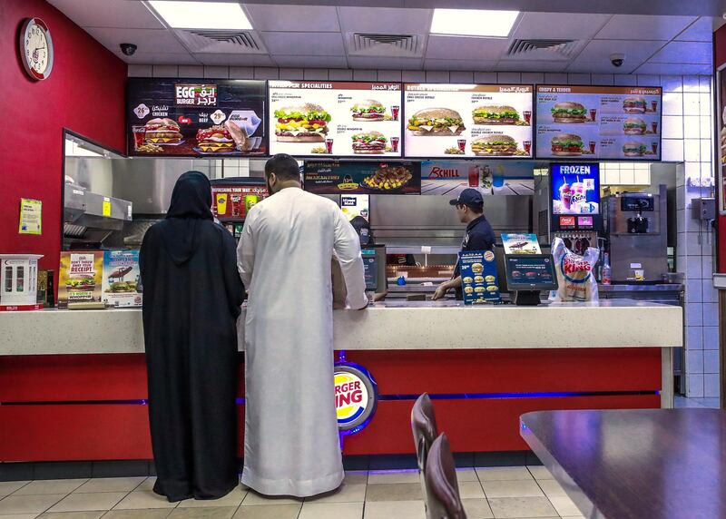 Abu Dhabi, U.A.E., June 7, 2018.    Ramadan Standalone. A couple buy food from a Burger King outlet for iftar at the Adnoc Al Samha staion.
Victor Besa / The National
Reporter:   
Section:  National