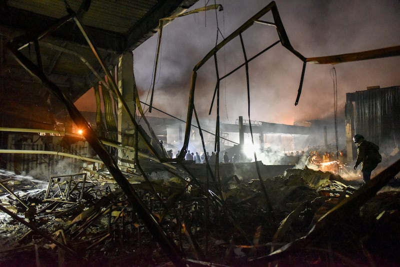 Firefighters clean the rubble of the destroyed Amstor shopping mall in Kremenchuk. EPA