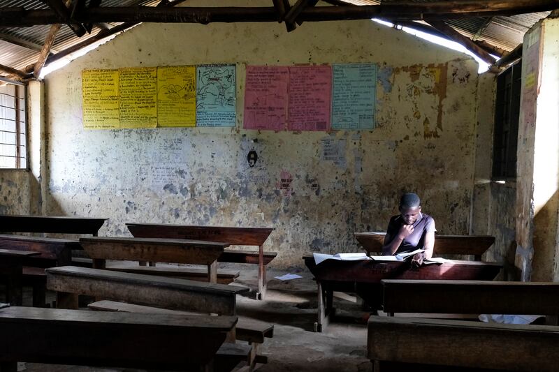 A pupil revises in a classroom at Madudu Catholic Church school, where many are staying away owing to the risk of Ebola. AP