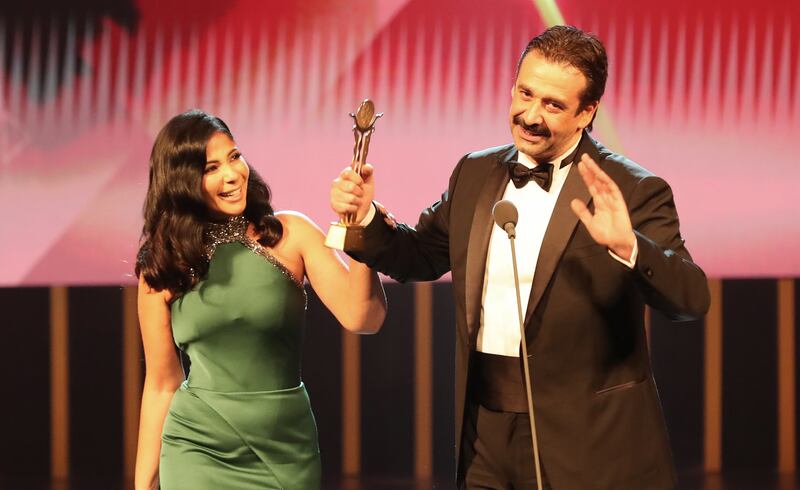 Egyptian actor Karim Abdel Aziz receives the Faten Hamama Honorary Award from Egyptian actress Mona Zaki during the opening ceremony.