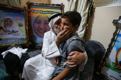 Mahmoud Issa, who lost his daughter and a grandchild in an Israeli bombing in May, kisses his grandson. Reuters