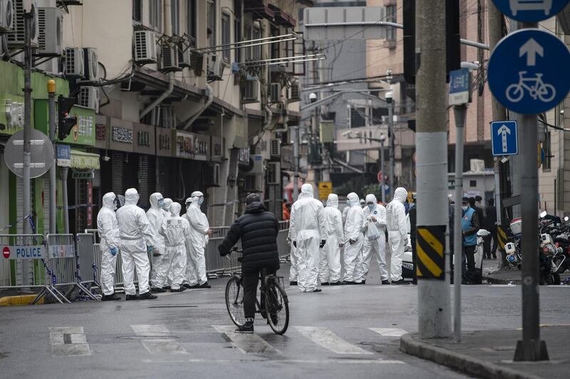 Police officers wearing personal protective equipment  stand guard near the Zhaotong Road neighborhood, placed under lockdown due to Covid-19 cases, in Shanghai, China. Bloomberg
