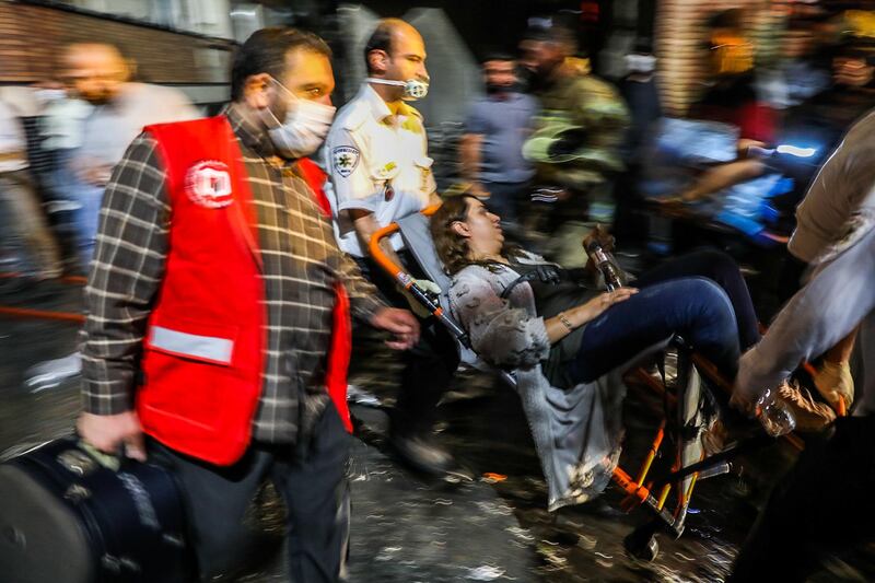Medics carry away a woman in a wheelchair. AFP Photo
