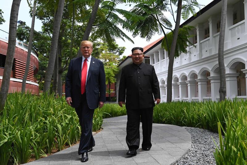 TOPSHOT - North Korea's leader Kim Jong Un (R) walks with US President Donald Trump (L) during a break in talks at their historic US-North Korea summit, at the Capella Hotel on Sentosa island in Singapore on June 12, 2018. Donald Trump and Kim Jong Un became on June 12 the first sitting US and North Korean leaders to meet, shake hands and negotiate to end a decades-old nuclear stand-off. / AFP / SAUL LOEB
