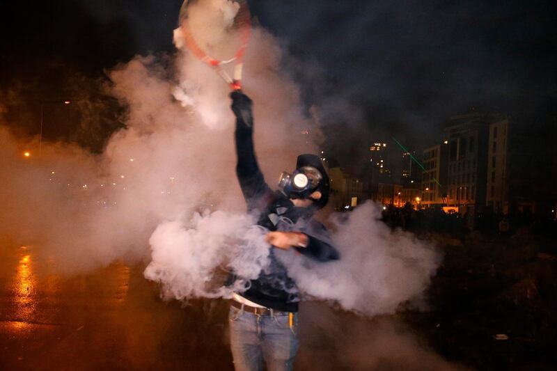 An anti-government demonstrator hits a tear gas canister back at riot police in Beirut. AP Photo