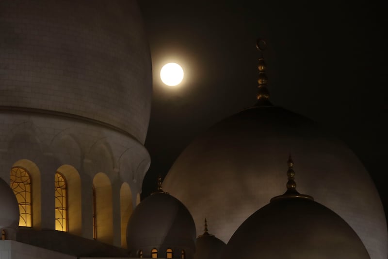 The supermoon appears above Sheikh Zayed Grand Mosque in Abu Dhabi, on Wednesday. Khushnum Bhandari / The National
