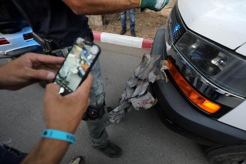 A man uses his mobile phone to photograph the remnants of a rocket launched from the Gaza Strip, on the outskirts of Jerusalem. Reuters