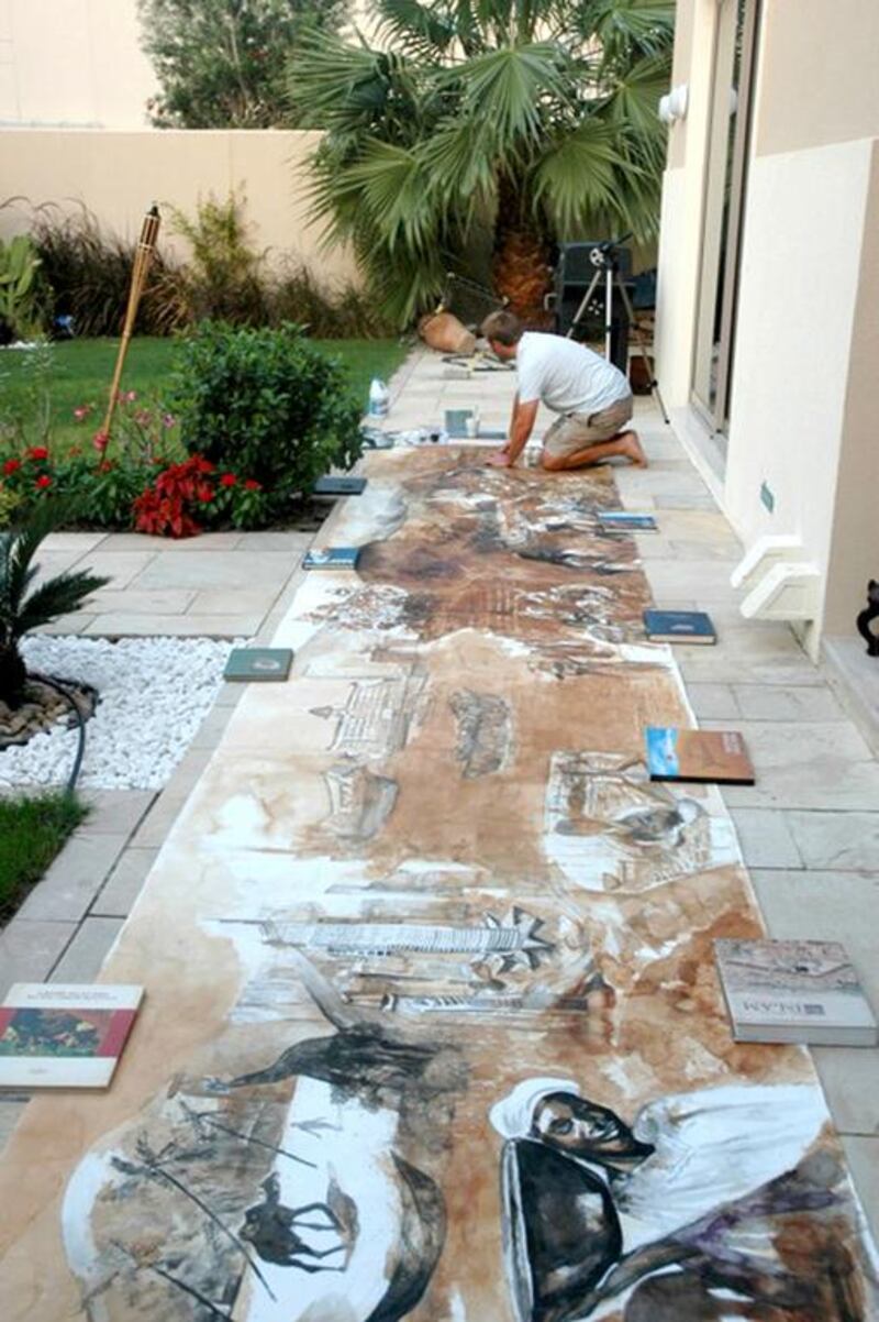 Andrew Field works on his seven-metre-long tea-leaves painting, which is on display at the Dubai Multi Commodities Centre in Almas Tower, JLT, Dubai. Courtesy Andrew Field