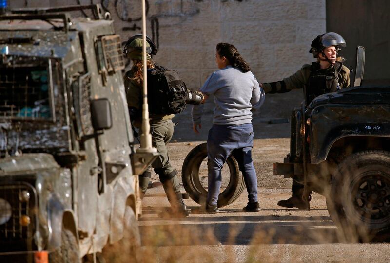 Israeli soldiers detain a Palestinian girl during clashes in Ramallah. AFP