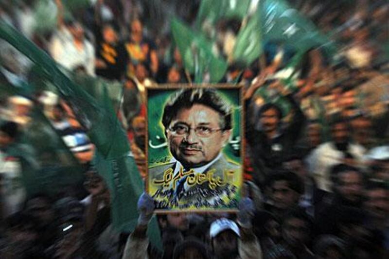 A supporter of the All Pakistan Muslim League, the party of the former Pakistan president, Pervez Musharraf, holds his portrait on Sunday during a public meeting in Karachi. Mr Musharraf has said he would return home by the end of this month after more than three years of self-exile.
