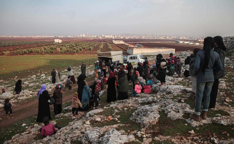 Displaced Syrians from the south of Idlib province receive food aid from a truck in the countryside west of the town of Dana in the northwestern Syrian region.  AFP