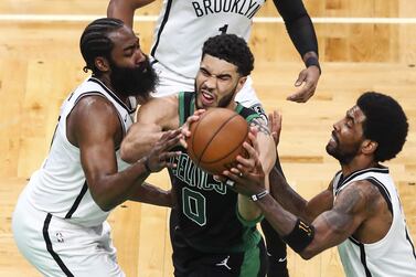 Jayson Tatum of the Boston Celtics drives to the basket while guarded by James Harden and Kyrie Irving of the Brooklyn Nets. AFP