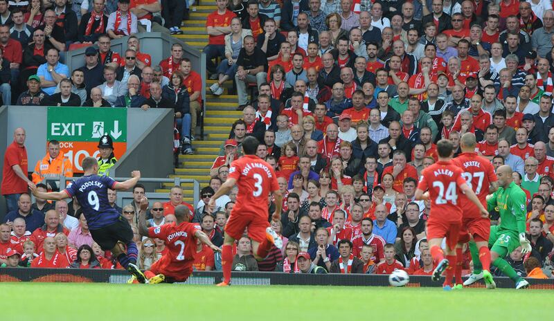 epa03380109 Arsenal's Lukas Podolski (left) fires in the opening goal during the English Premier League soccer match Liverpool vs Arsenal at Anfield in Liverpool, Britain, 02 September 2012.  EPA/PETER POWELL DataCo terms and conditions apply.  http//www.epa.eu/downloads/DataCo-TCs.pdf *** Local Caption ***  03380109.jpg