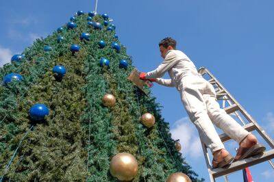 Young labourer, Hussam, re-paints the ornaments of the Christmas tree in Fuheis, a predominantly Christian town in Jordan. Amy McConaghy / The National