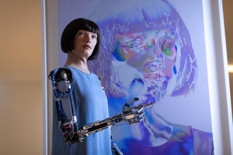 Ai-Da in front of one of her artworks during 'Ai-Da: The World's First Robot Artist' press view at Design Museum in London. Getty Images