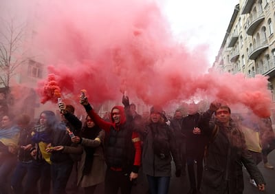 Demonstrators hold smoke grenades as they gather in central Kiev on October 6, 2019 to protest broader autonomy for separatist territories, part of a plan to end a war with Russian-backed fighters. Protesters chanted "No to surrender!", with some holding placards critical of President Volodymyr Zelensky in the crowd, which police said had swelled to around 10,000 people. Ukrainian, Russian and separatist negotiators agreed on a roadmap that envisages special status for separatist territories if they conduct free and fair elections under the Ukrainian constitution. / AFP / Genya SAVILOV
