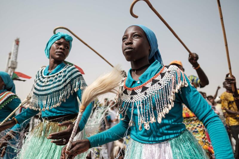 Members of traditional music and dance group perform before a rally for supporters of Sudan's ruling Transitional Military Council (TMC) in the village of Abraq.   AFP