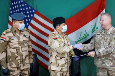 US Brigadier General Vincent Barker (R) shakes hands with Iraqi General Mohammed Fadel (C), during the hand over of Qayyarah Airfield West from US-led coalition forces to Iraqi Security Forces, in the south of Mosul, Iraq March 26, 2020. Reuters 