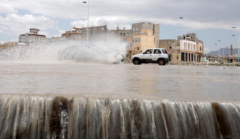 Vehicles drive through a flooded stream of rainwater following heavy rains in Sana'a, Yemen.  EPA