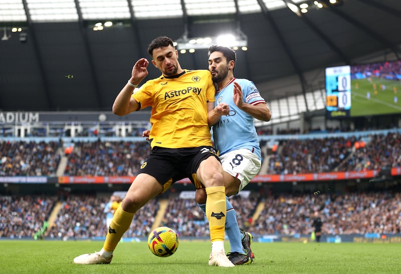 Ilkay Gundogan of Manchester City takes a shoulder in the face off Max Kilman, a challenge that earned the Wolves player a yellow card. Getty