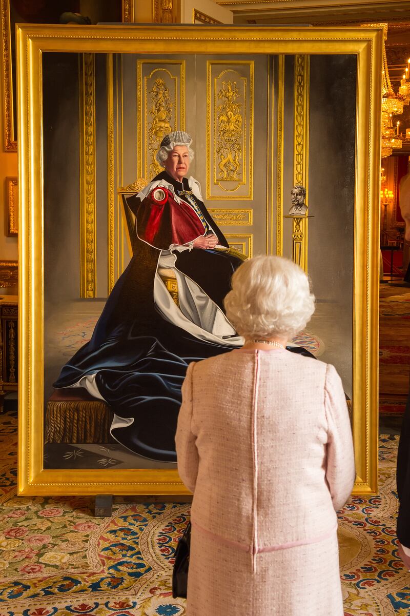 Queen Elizabeth views a portrait of her by British artist Henry Ward that marked six decades of patronage to the British Red Cross. Getty