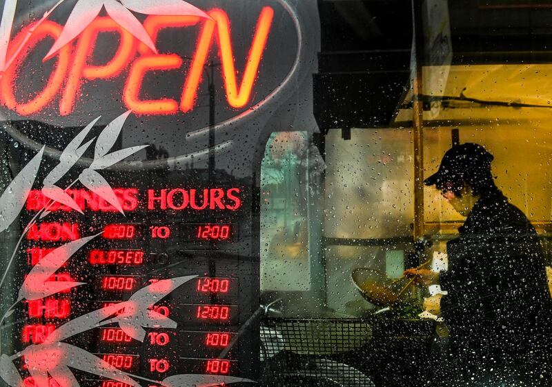 A chef cooks Chinese food while the restaurant is open for curb-side pickup in Toronto. The Canadian Press via AP