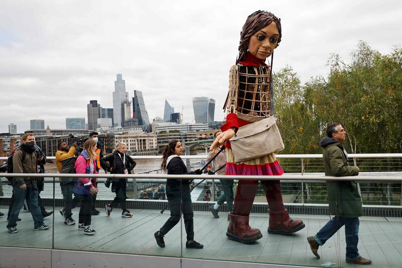 Little Amal crosses the Millenium Bridge in London. AFP