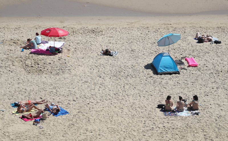 People socially distance as they sunbathe on Bournemouth beach in Dorset. PA
