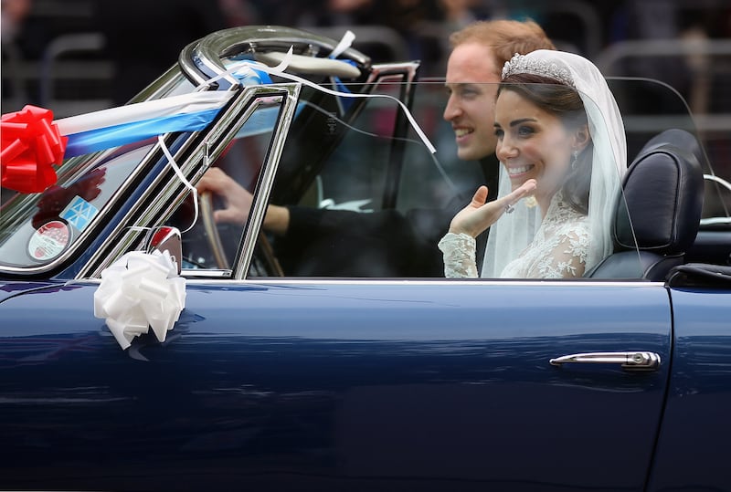 Prince William, Duke of Cambridge, and Kate, Duchess of Cambridge, drive from Buckingham Palace to Clarence House in a vintage Aston Martin after their wedding reception in 2011.