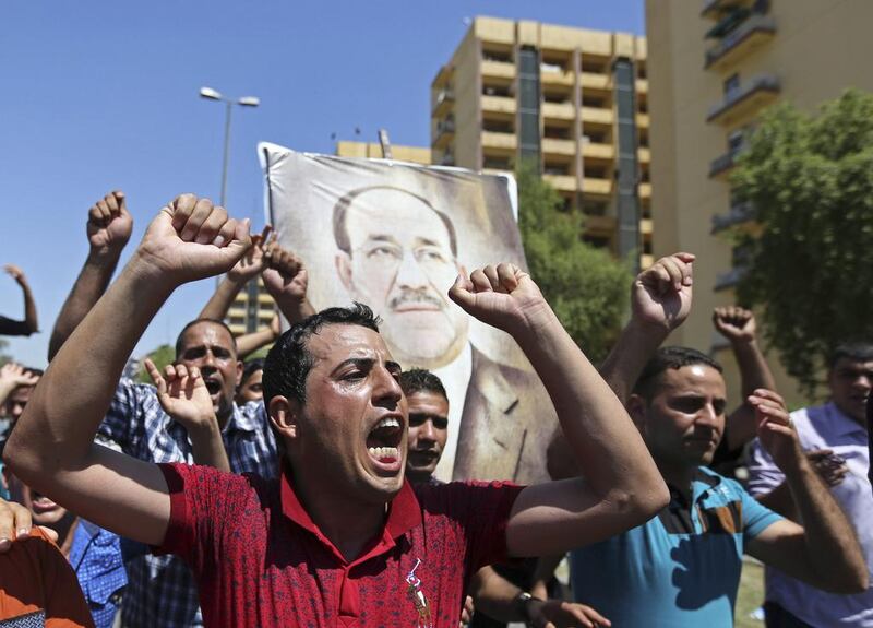 Iraqis chant pro-government slogans and display placards bearing a picture of embattled prime minister Nouri Al Maliki during a demonstration in Baghdad on August 11, 2014. AP 