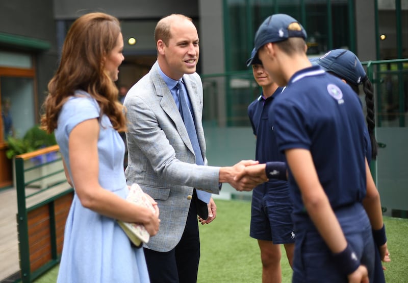 Catherine, Duchess of Cambridge and Prince William, Duke of Cambridge  meet ballboys and ballgirls ahead of the Men's Singles Final on day thirteen of the Wimbledon Championships at the All England Lawn Tennis and Croquet Club, Wimbledon on July 14, 2019. Kate is wearing Emilia Wickstead and holding a vintage bag. Photo: AP