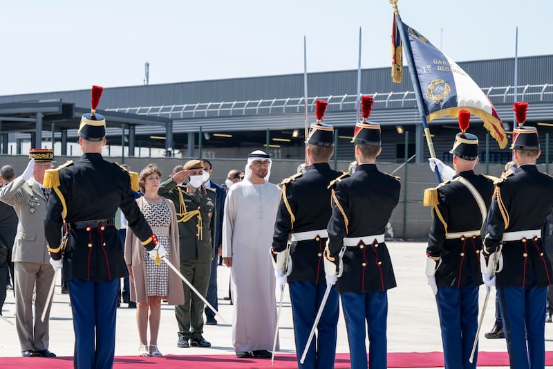 Sheikh Mohamed stands for the national anthem. Catherine Colonna, French Minister for Europe and Foreign Affairs, is also pictured. Photo: Presidential Court