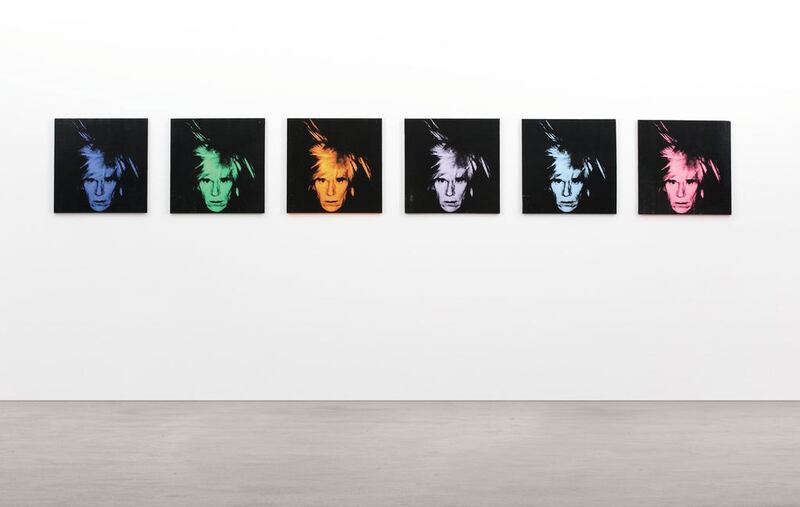 This picture shows 'Six Self Portraits' by Andy Warhol hanging in Sotheby's London gallery. Works by Warhol and Jeff Koons are among the highlights at auction next month. Sotheby’s is offering the 1986 group of six Warhol self-portraits that expected to bring between $25 million and $35 million on May 14. The identical silk-screen images in different colours depict Warhol in his famous 'fright wig.' (AP Photo / Sotheby's / April 2014)