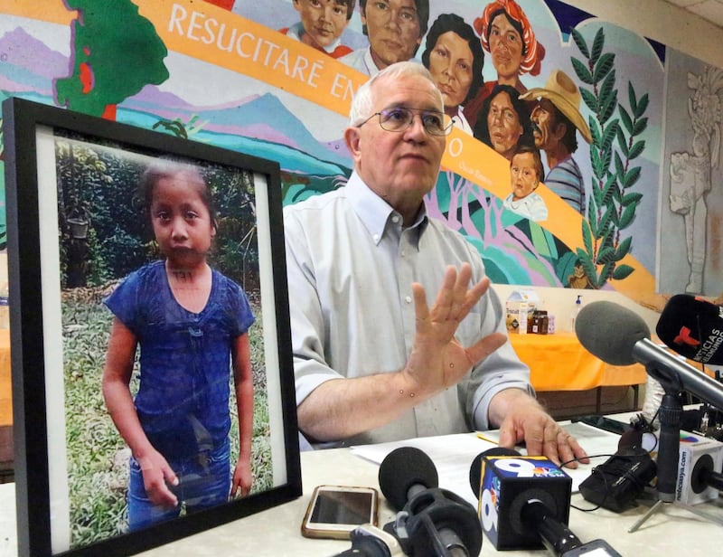 Annunciation House director Ruben Garcia answers questions from the media after reading a statement from the family of Jakelin Caal Maquin, pictured at left, during a press briefing at Casa Vides, Saturday, Dec. 15, 2018, in downtown El Paso, Texas. Maquin had received her first pair of shoes several weeks ago, when her father said they would set out together for the U.S., thousands of miles from her impoverished Guatemalan village. Instead she died in a Texas hospital two days after being taken into custody by U.S. Border Patrol agents in a remote stretch of New Mexico desert. (Rudy Gutierrez/The El Paso Times via AP)