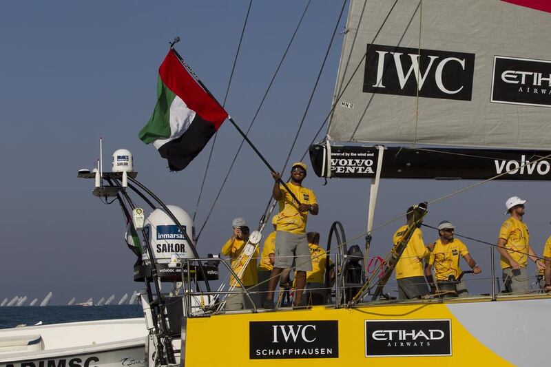 Adil Khalid waves the UAE flag as Azzam sails into port on Saturday in Abu Dhabi at the end of Leg 2 of the Volvo Ocean Race. Ian Roman / Abu Dhabi Ocean Racing