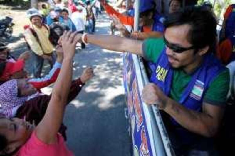 Filipino boxing great Manny Pacquiao, a candidate for Congressman at the seven-township Sarangani province, greets supporters as his campaign motorcade makes the rounds of townships on the second day of the official campaign period Saturday Mar.27, 2010 in Malungon township, Sarangani province in southern Philippines. Pacquiao, who made boxing history by winning seven championships in seven weight divisions and recently won a unanimous WBO Welterweight crown versus Joshua Clottey of Ghana, is now concentrating on another fight in the political arena as a candidate for congressman in Sarangani province in southern Philippines. (AP Photo/Bullit Marquez) *** Local Caption ***  XBM102_Philippines_Pacquiao_Election.jpg *** Local Caption ***  XBM102_Philippines_Pacquiao_Election.jpg