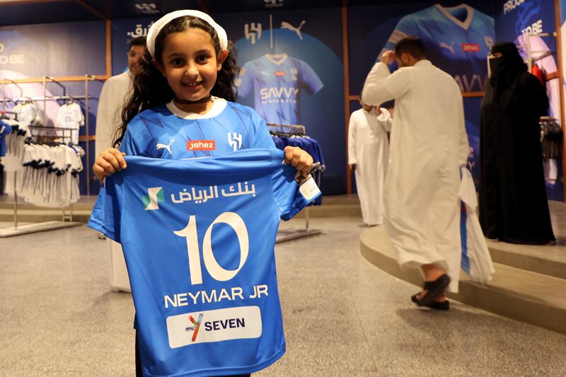 A young fan poses with a Neymar Al Hilal shirt in the club shop. Reuters