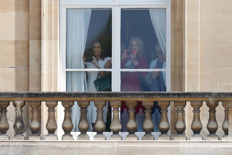 Guests including White House Press Secretary Sarah Sanders (L) watches from a balcony as the US President Donald Trump and US First Lady Melania Trump arrive for a welcome ceremony at Buckingham Palace. AFP
