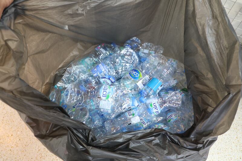 Workers collect plastic bottles for recycling. Nilanjana Gupta / The National