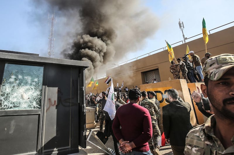 Members of the Iraqi pro-Iranian Hashed Al Shaabi group and protesters set fire to a sentry box in front of the US embassy building in the capital Baghdad. AFP