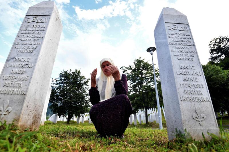 Bosnian Muslim Mejra Djogaz, 71, prays between the tombstones of Omer, 19, and Munib, 21, her two sons killed in the Srebrenica massacre, at the Potocari memorial cemetery. More than 6,600 victims lie at the cemetery while another 237 have been laid to rest at other sites. But more than 1,000 people have never been found. AFP